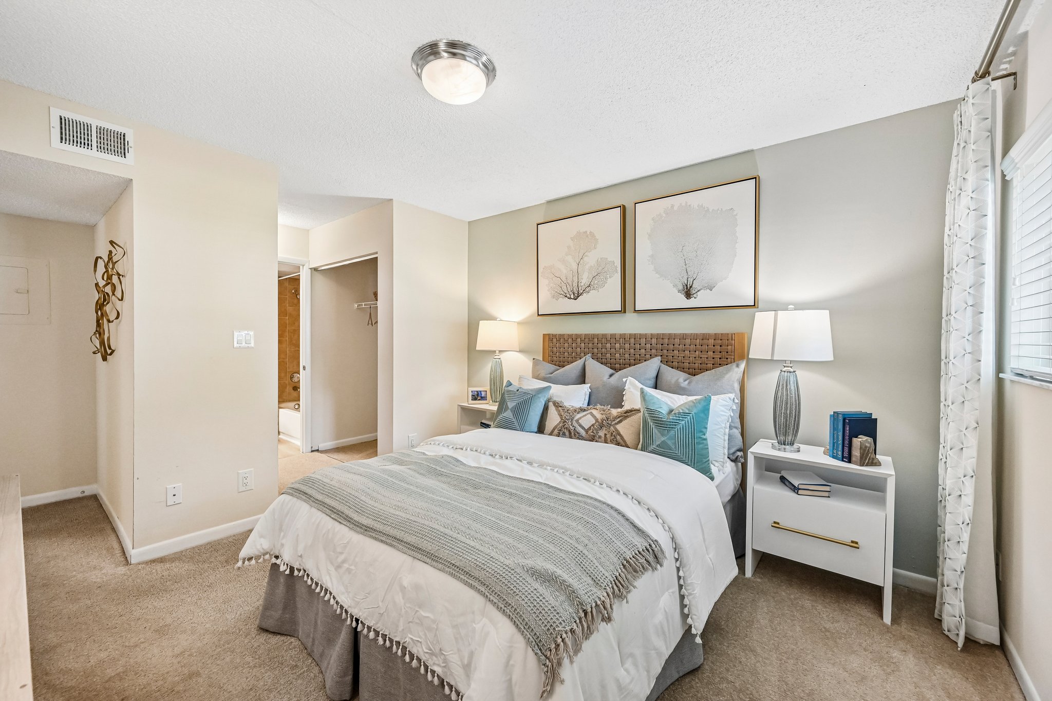 Bedroom with bed, dresser, and large window Azalea Village