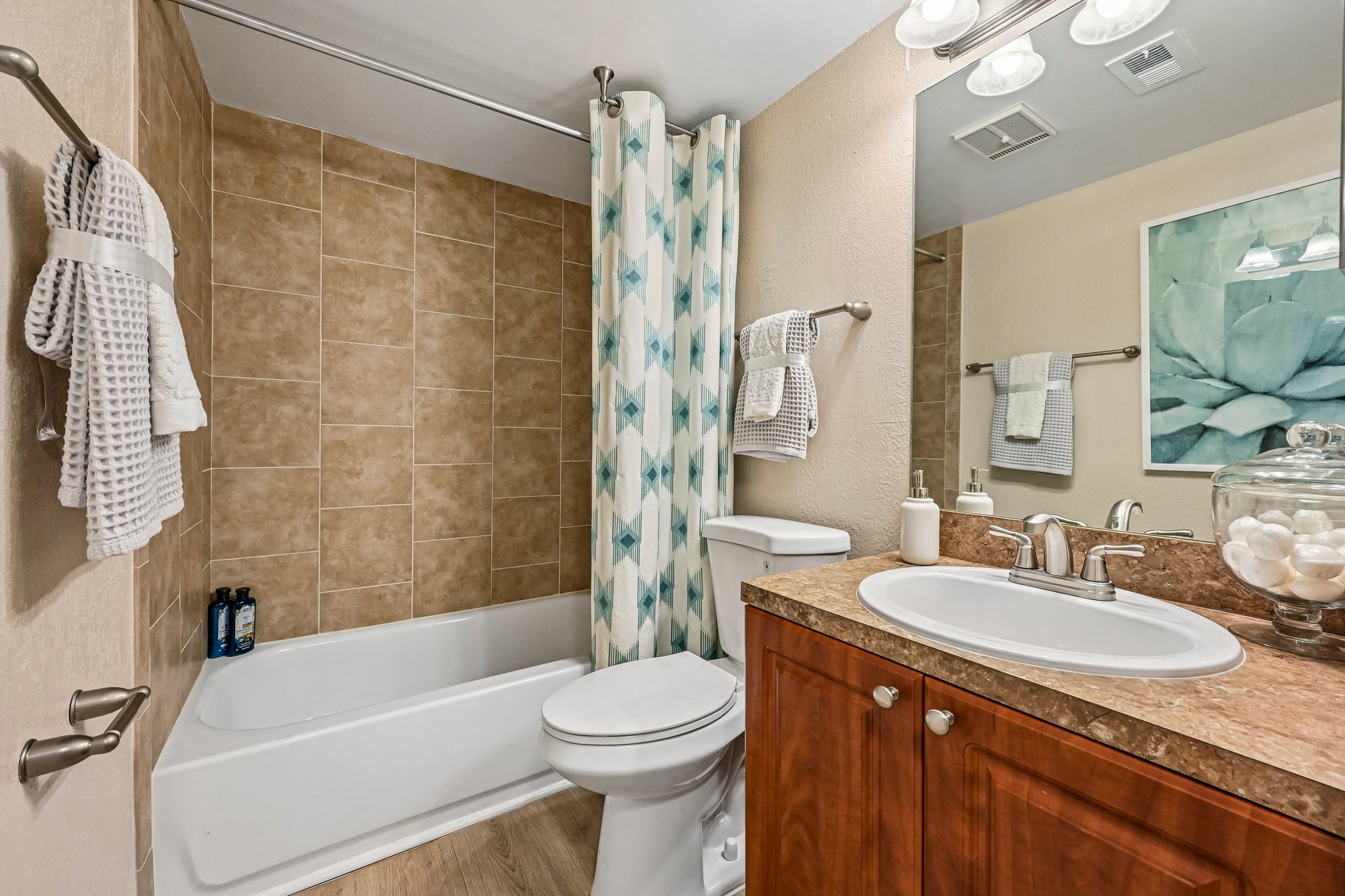 bathroom with tob/shower and brown cabinets Azalea Village