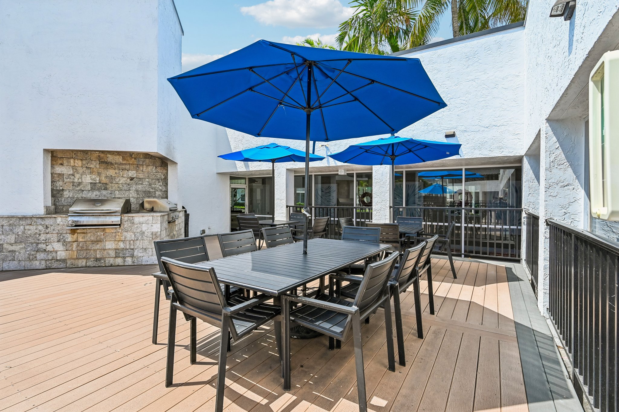 poolside picnic tables with blue umbrellas and bbq grills Azalea Village 