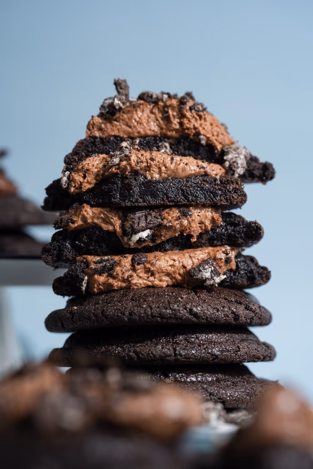 Stack of dark chocolate cookies filled with creamy chocolate mousse and cookie crumbs.