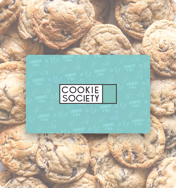 Cookie Society gift card on a pile of chocolate chip cookies.