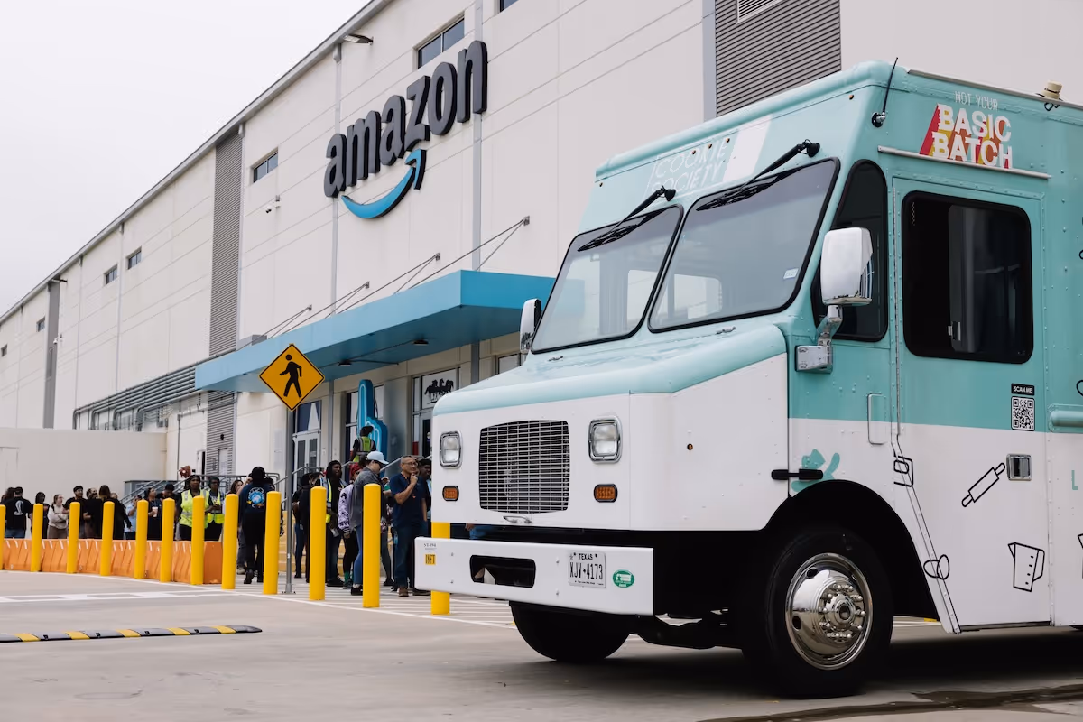 Line of people outside Amazon building near teal and white food truck with Basic Batch branding.