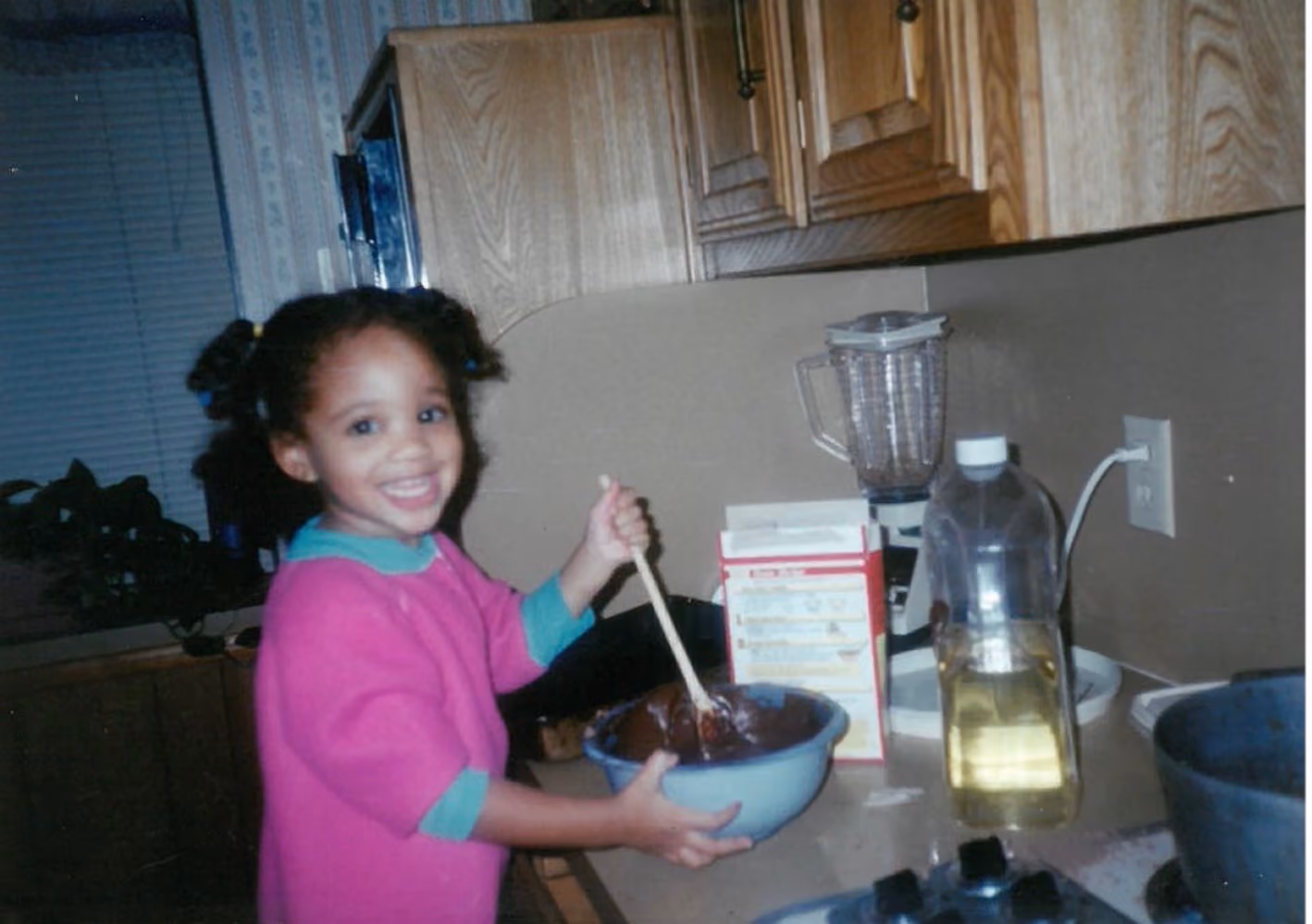 Young Marissa mixing batter in her family's kitchen in 1996
