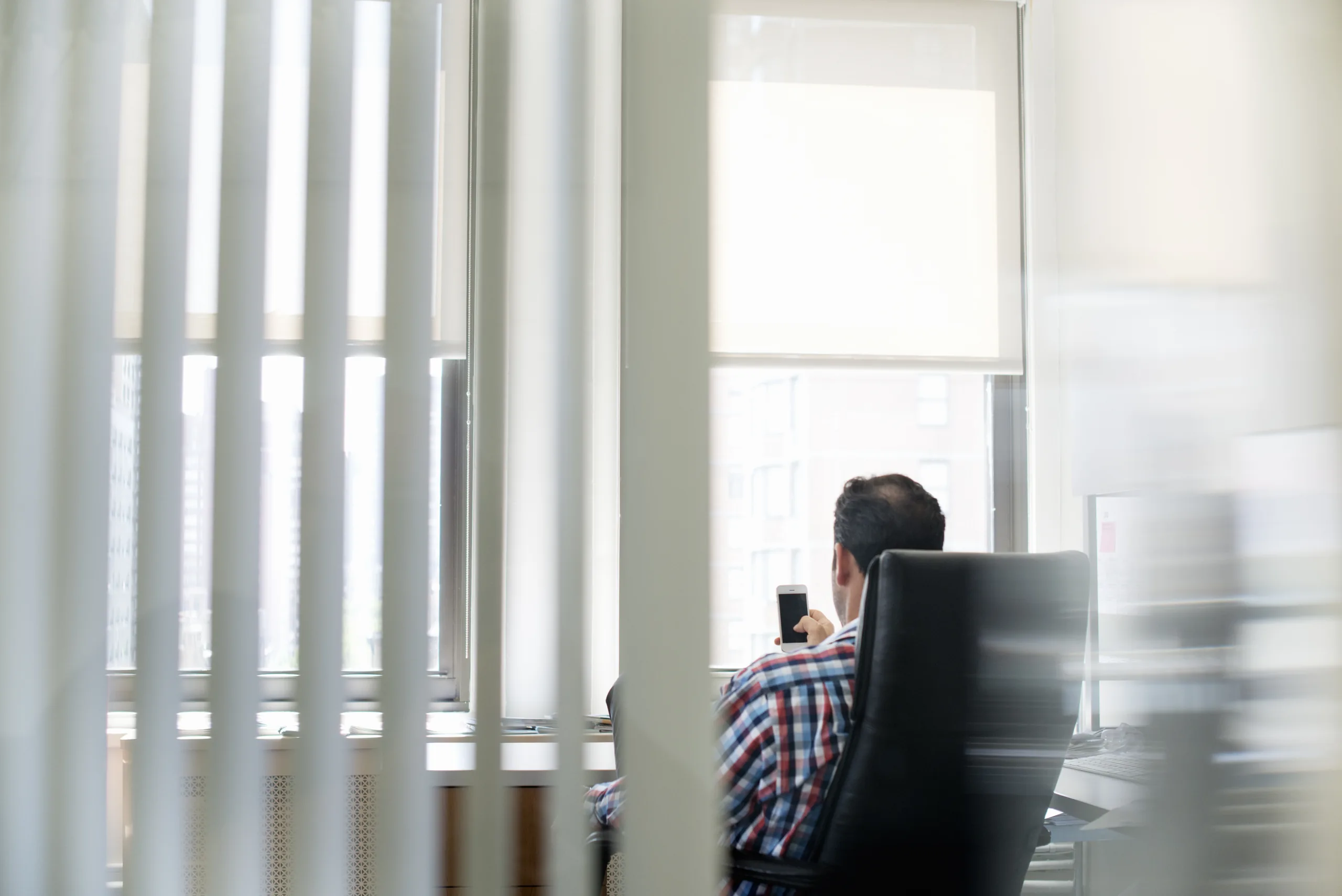 Businessman leaning back thoughtfully in a large office chair