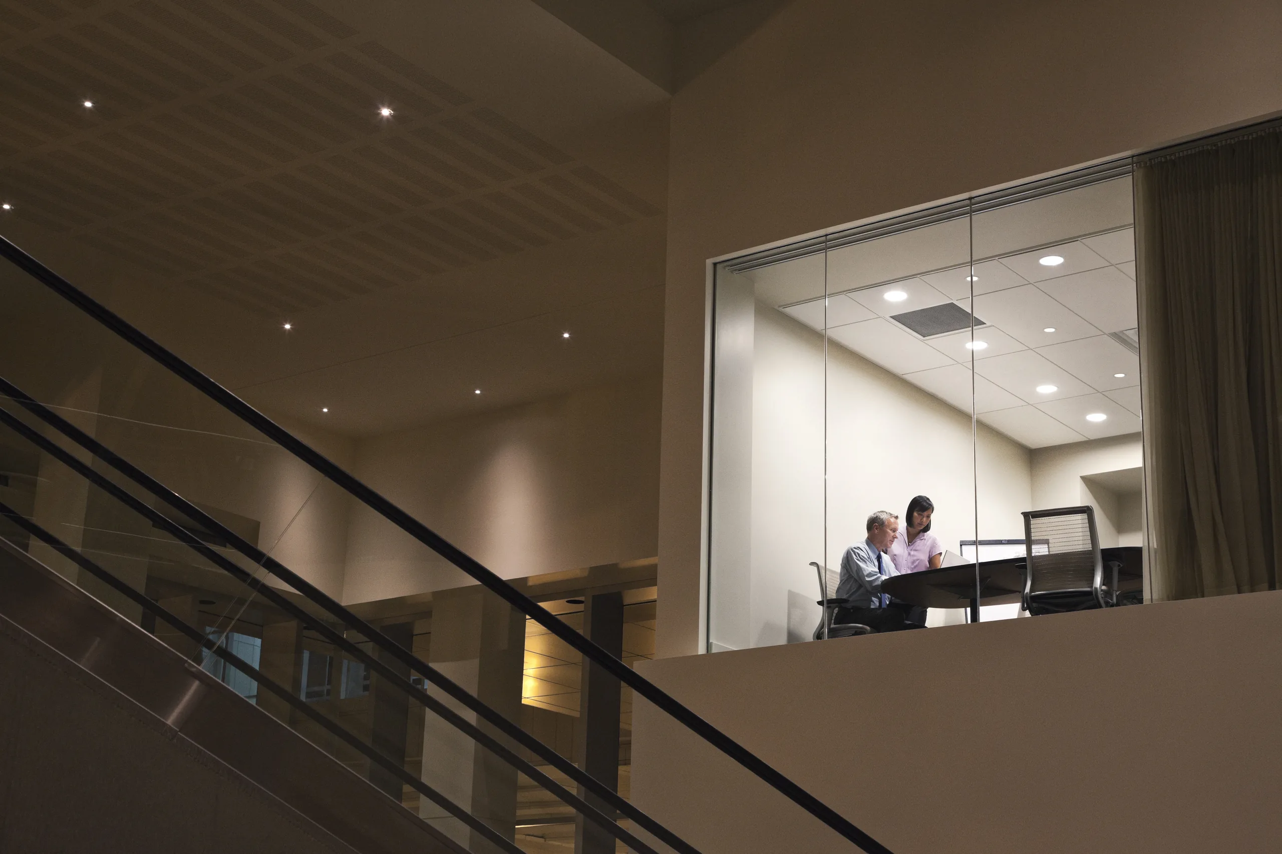 Business team meeting inside a glass-walled modern office