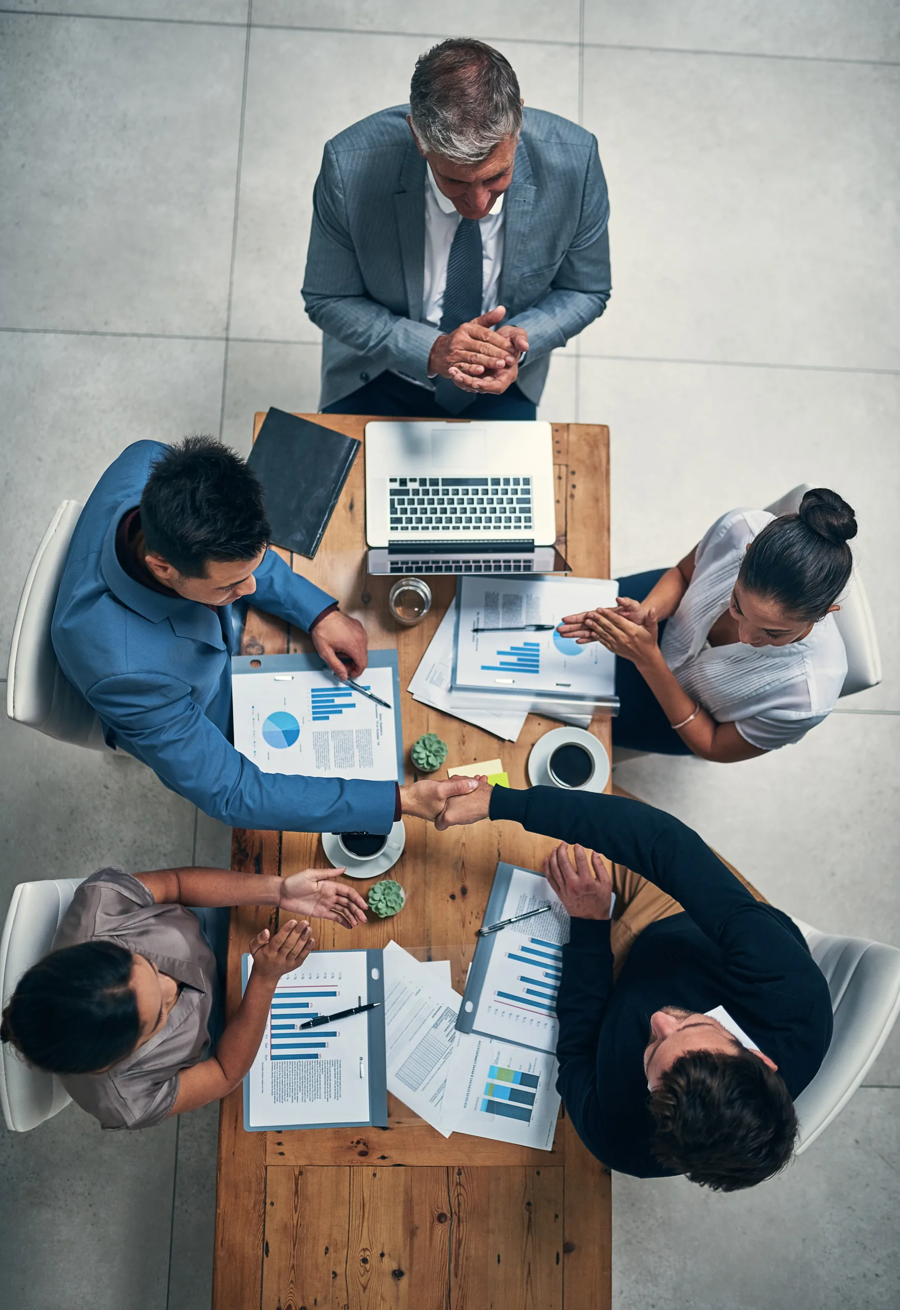Business colleagues shaking hands to close a deal in a meeting