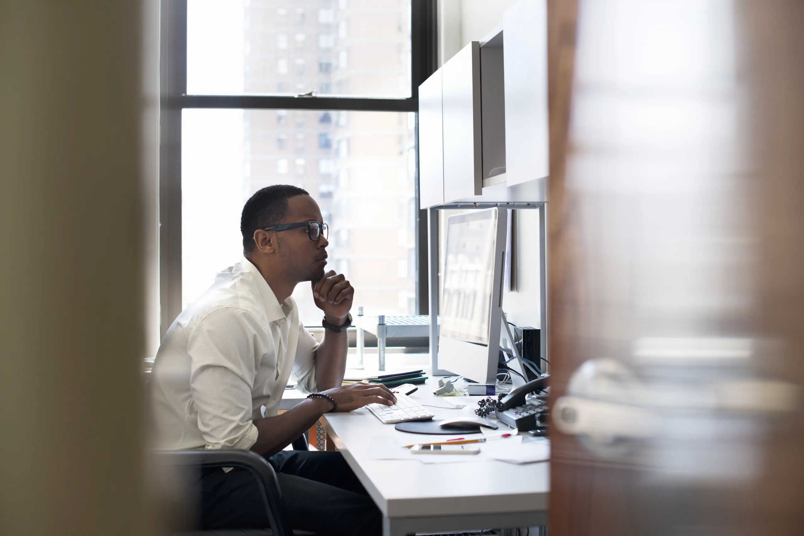Businessman pausing in thought while working at his desk