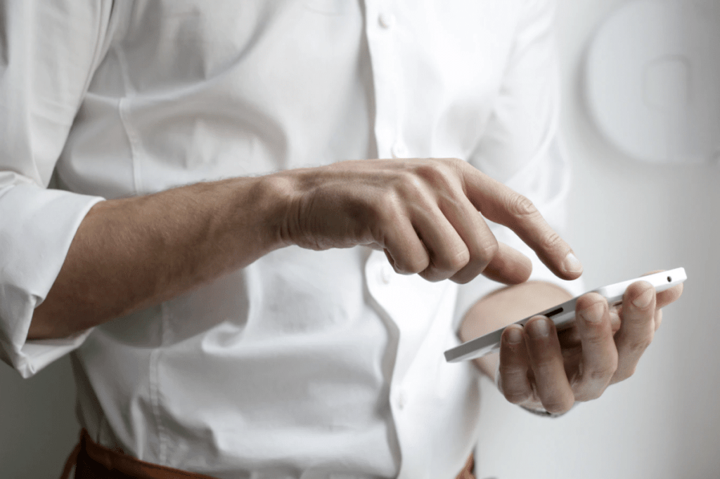 A man tying on his mobile phone.