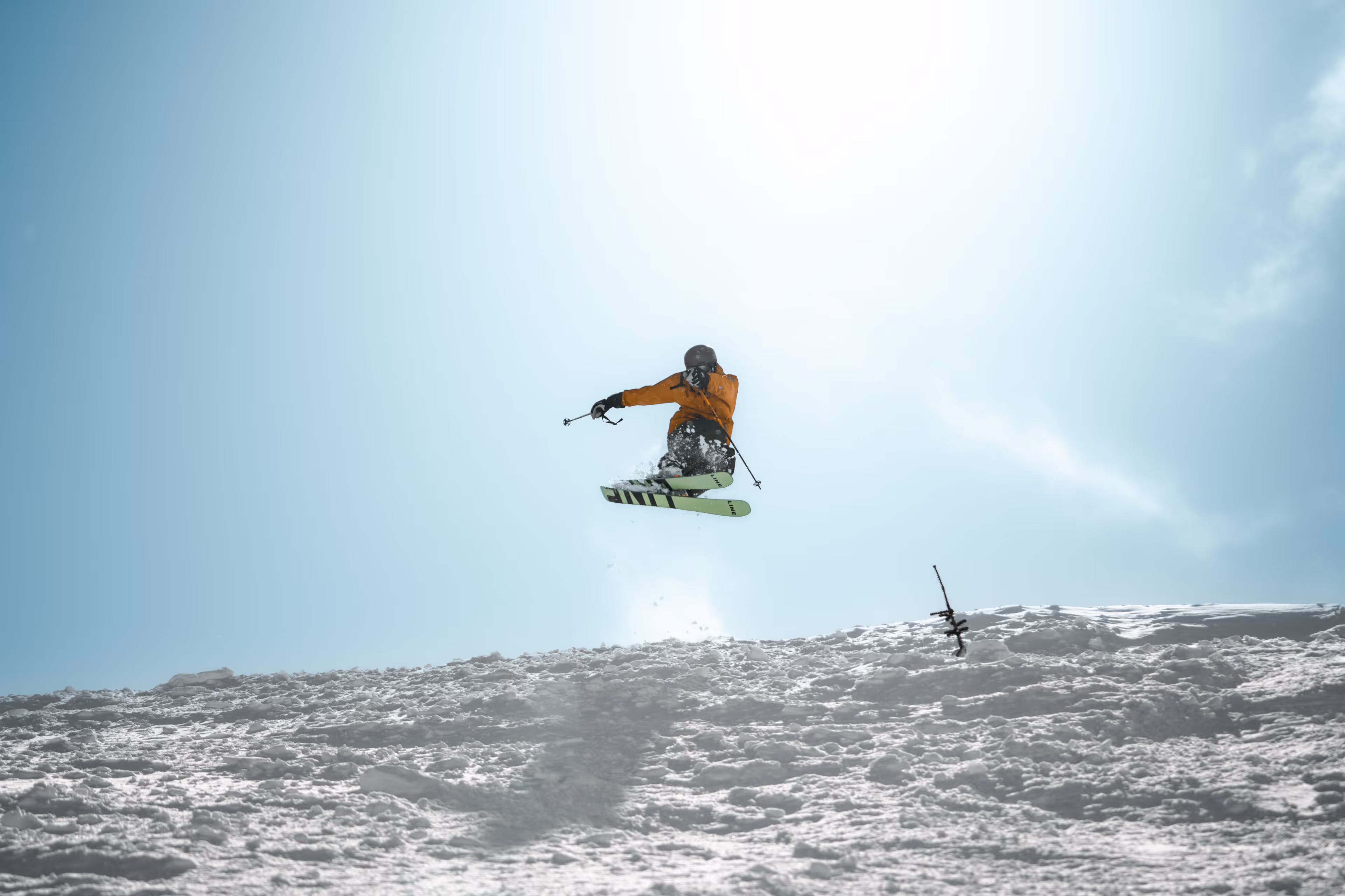Skier doing a shifty over a bank.