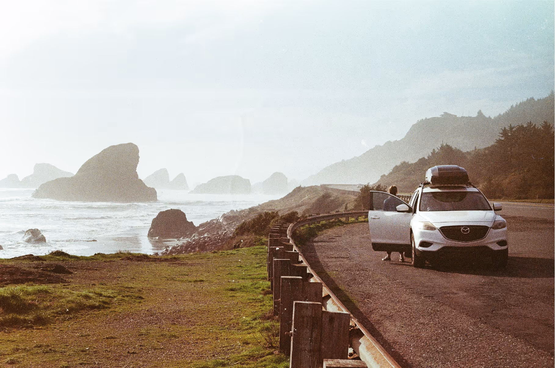 Film photo of a Mazda Cx-9 with a Thule Motion 3 XXL on top next to the ocean in Oregon, USA. 