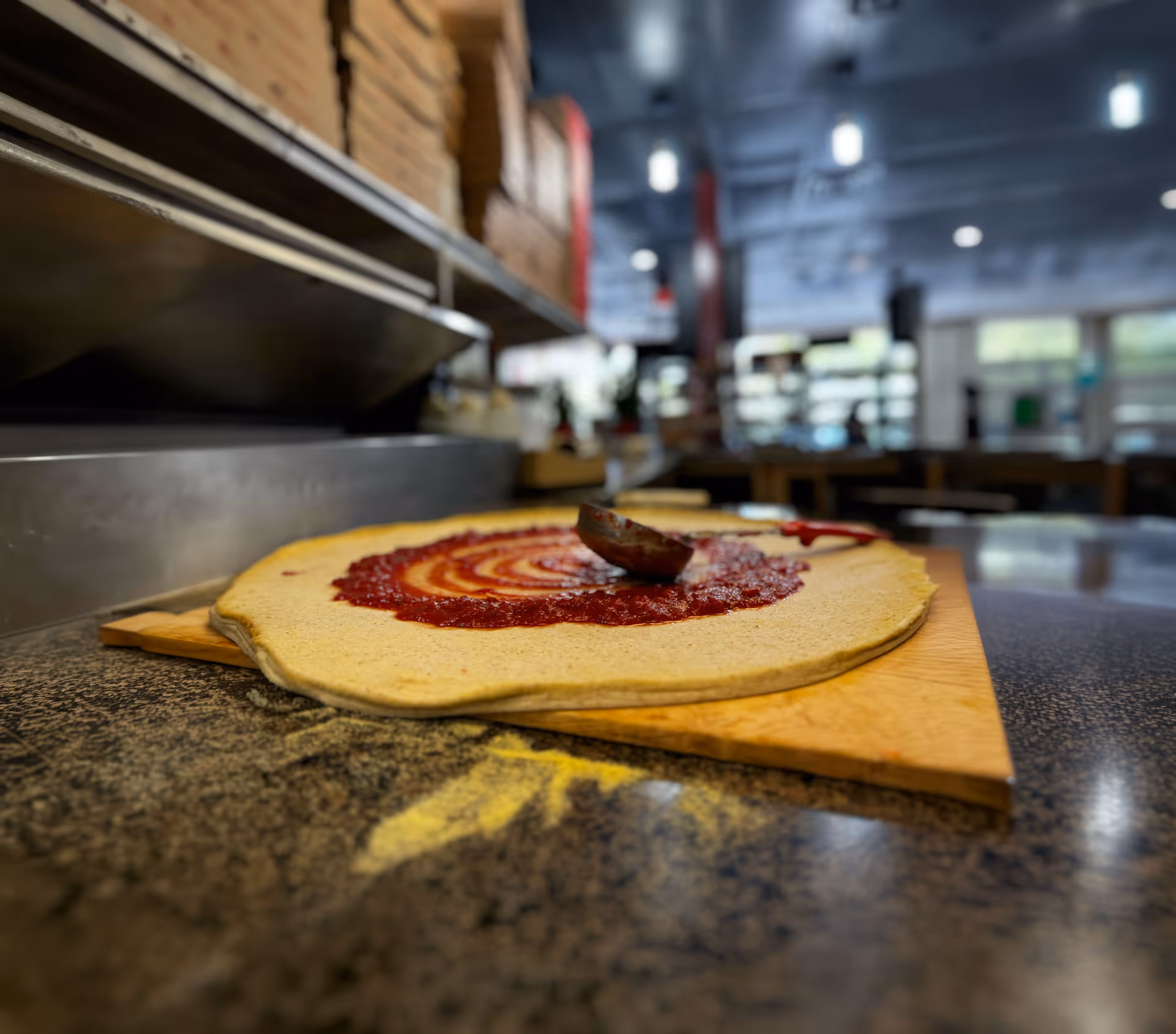 Close-up of bubbling pepperoni pizza slices with melted cheese and golden crust on a black surface.