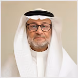 Middle-aged man in traditional white Saudi attire and glasses with a neutral background.