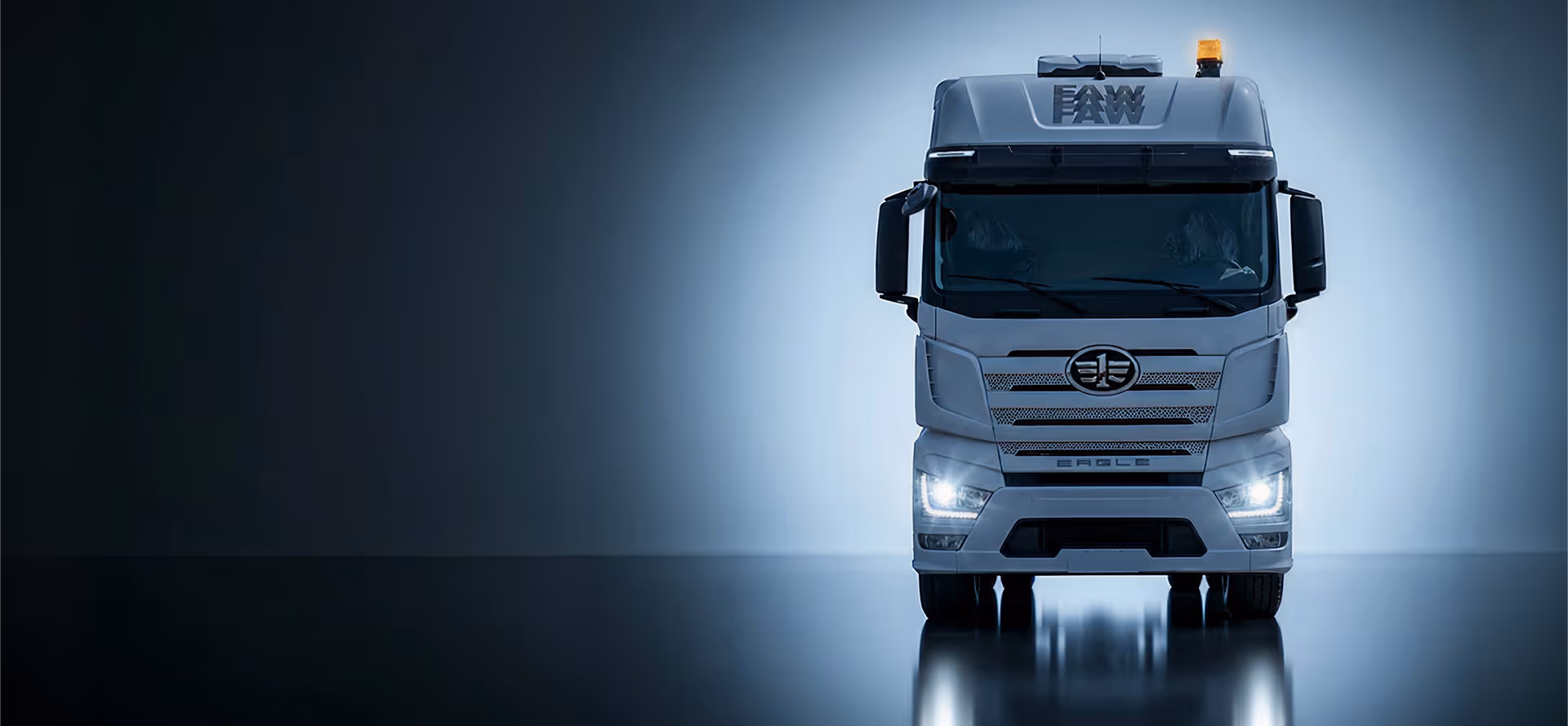 Front view of a large white FAW Eagle truck with headlights on in a dark environment.