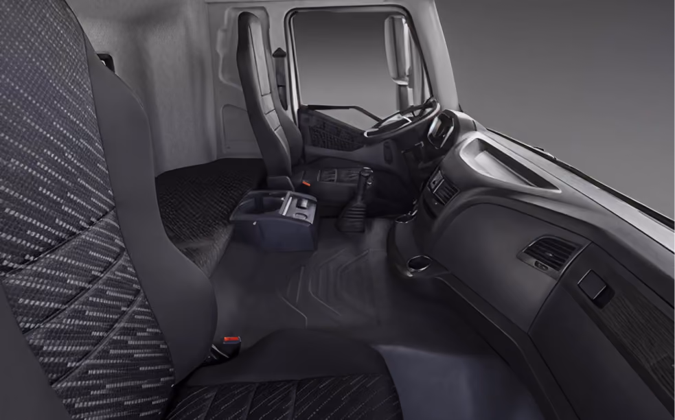 Interior cabin of a truck showing two front seats, steering wheel, dashboard, and center console.