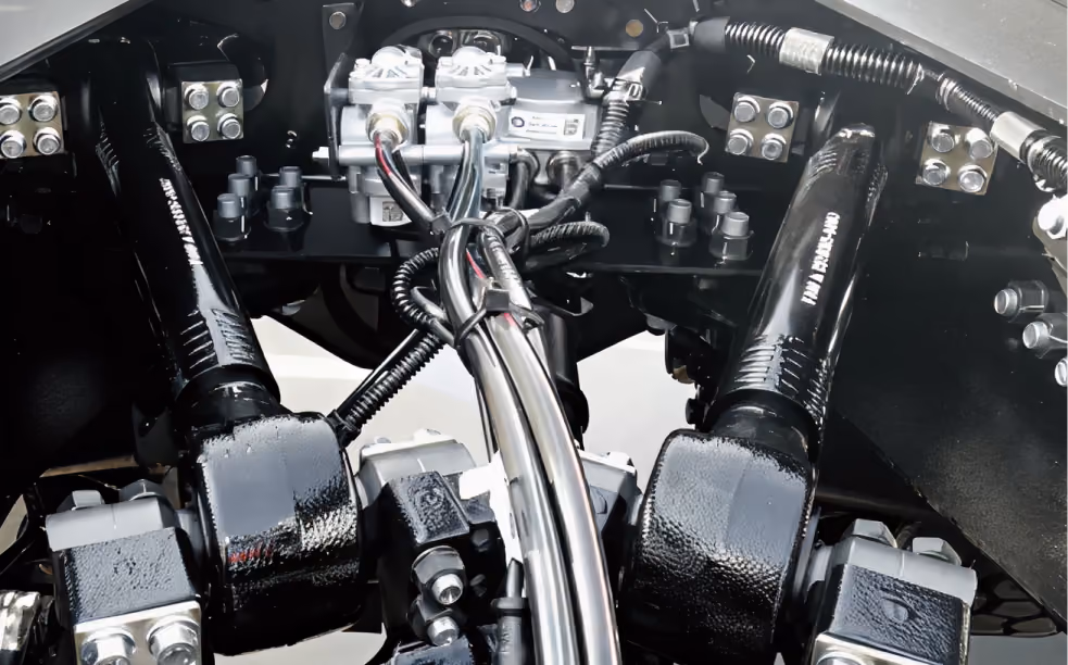 Close-up of a mechanical system with black hydraulic arms and silver metal tubing and connectors.