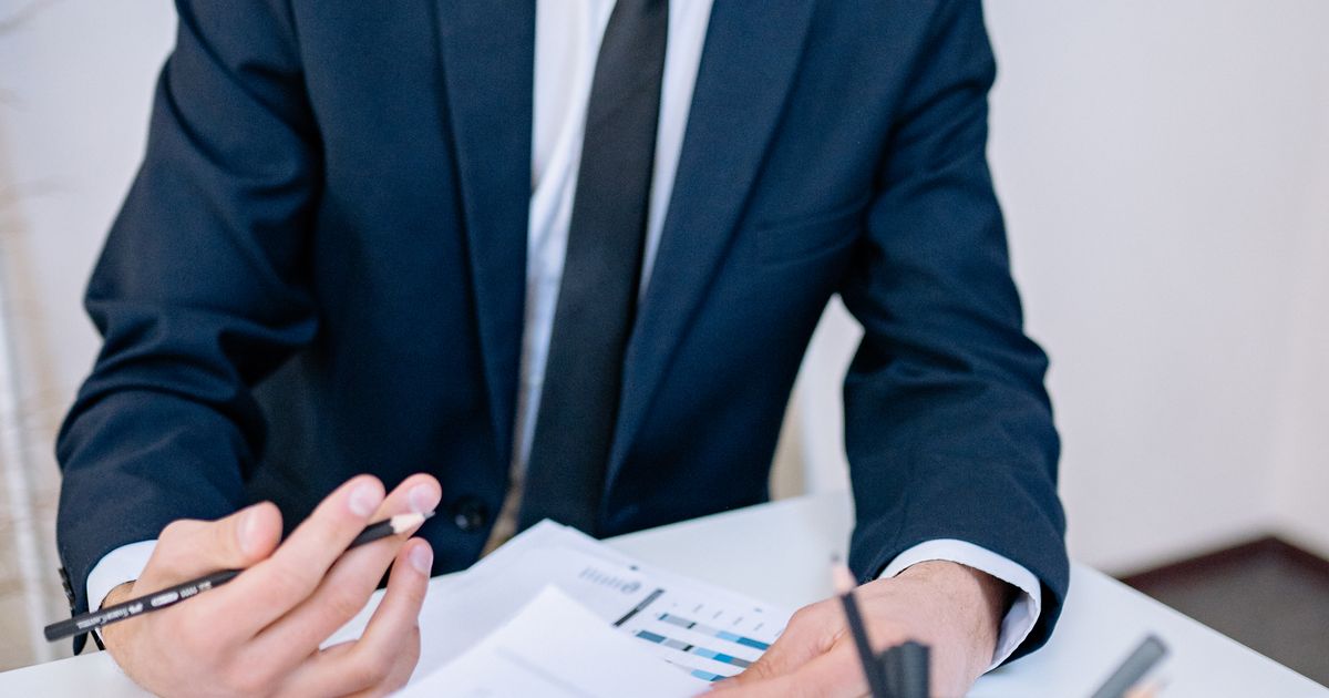 Finance executive in a suit reviewing performance reports at a desk