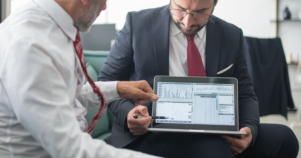 Business leaders reviewing an enterprise software dashboard on a laptop