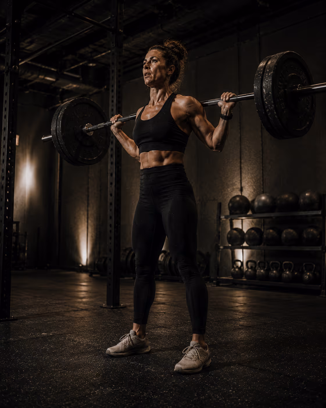 A female athlete squatting with a barbell. 