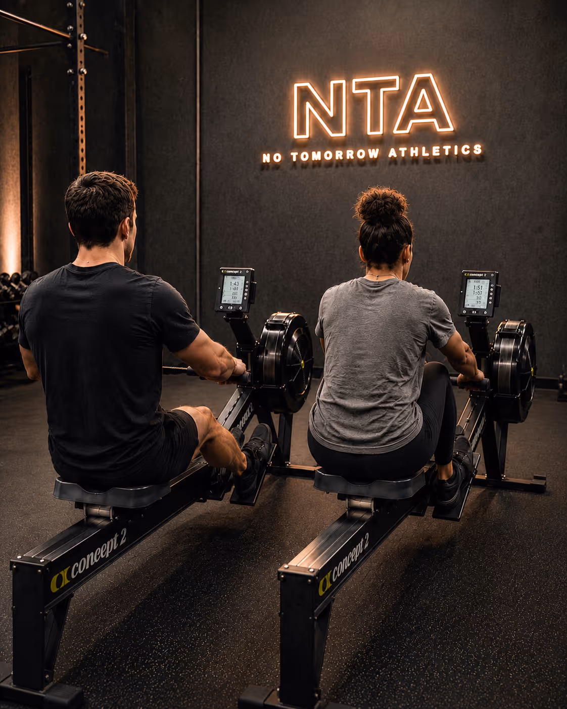 Two athletes rowing on a rower.