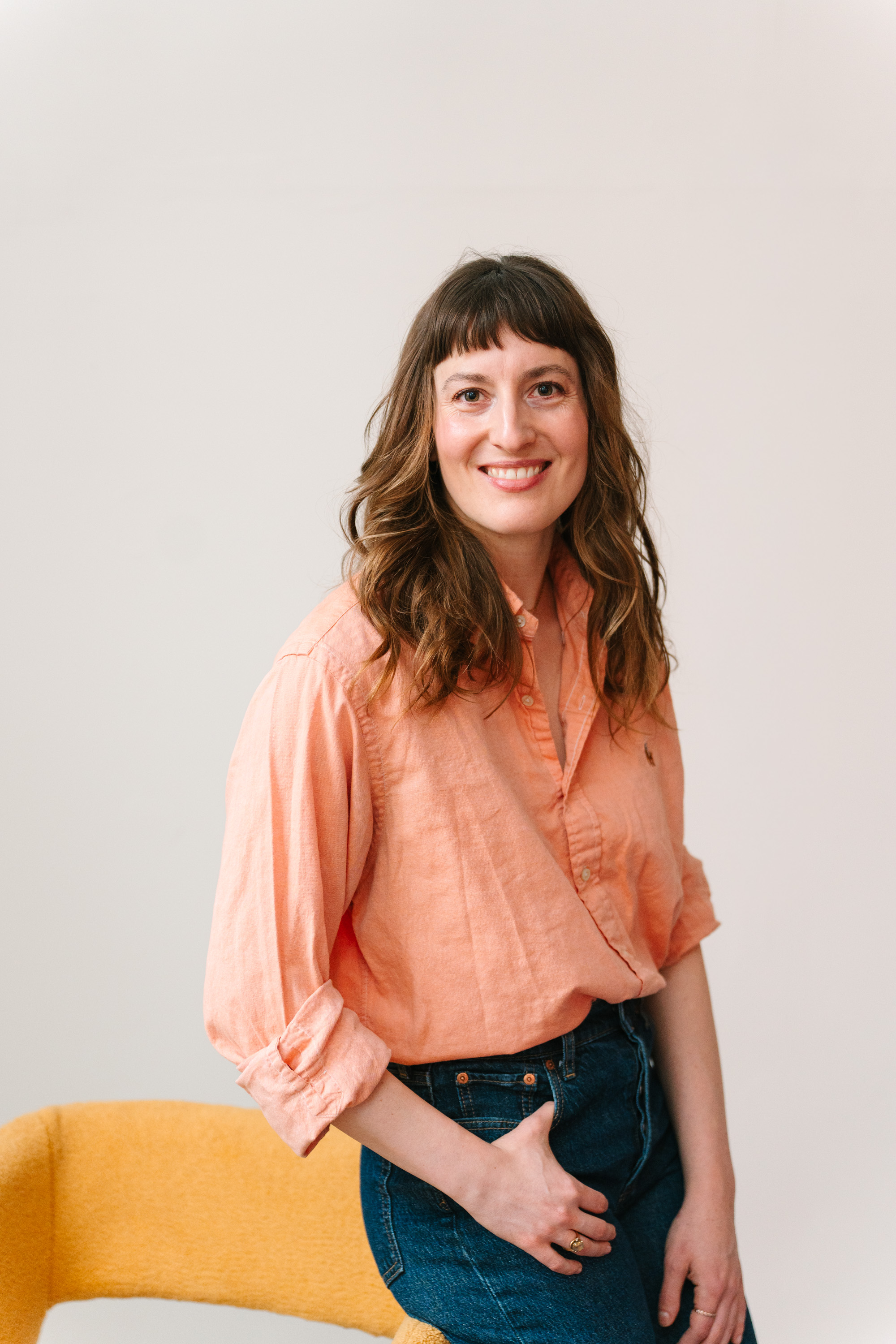 Deanne Vincent, founder of Fruition Co., smiling in a peach shirt