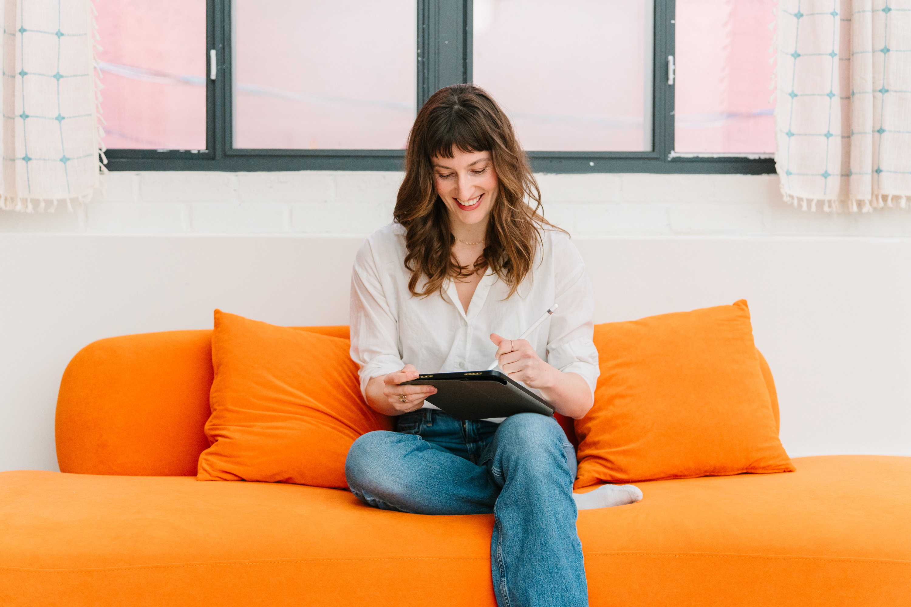 Deanne Vincent on an orange sofa with a tablet