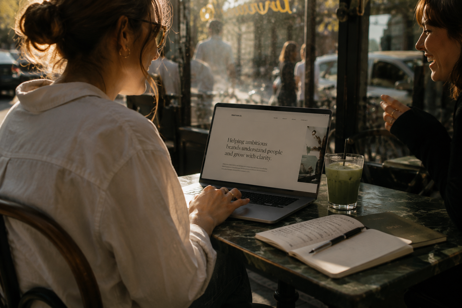 Woman working on a laptop at a street café