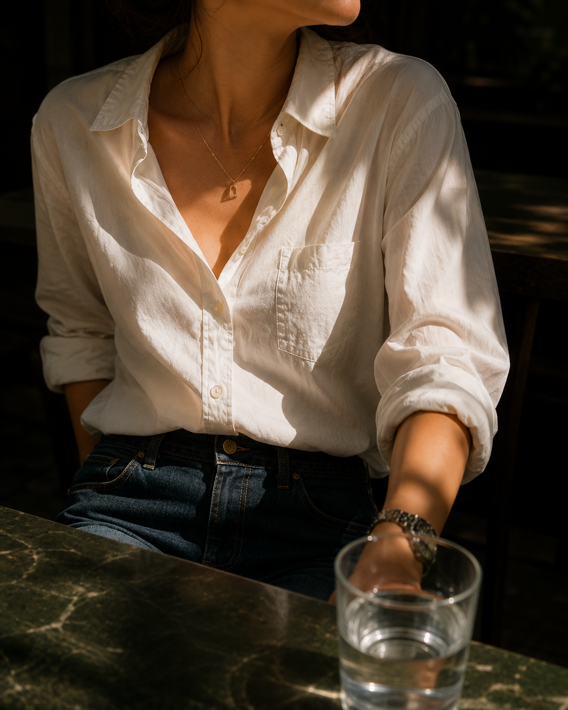Woman in a white button-down shirt at a café table