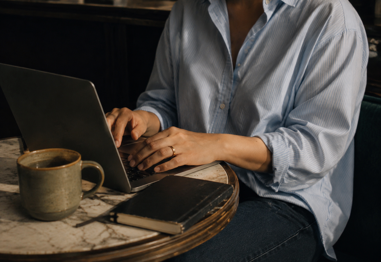Woman working on a laptop at a café table