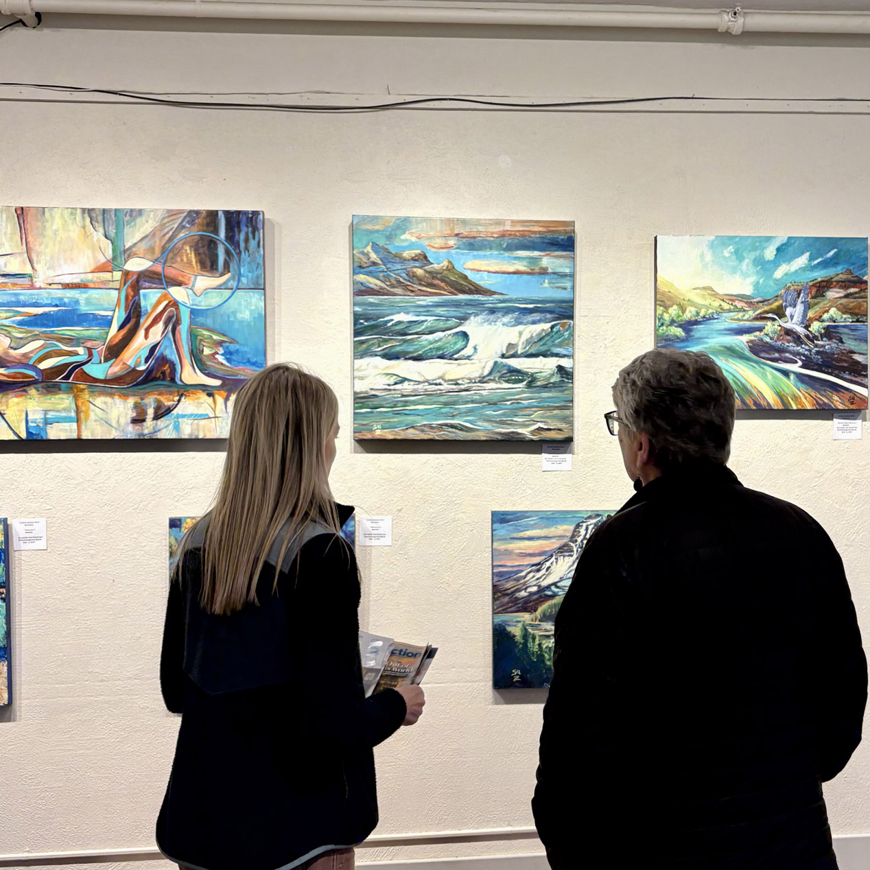 Visitors viewing coastal paintings in the BCAC gallery