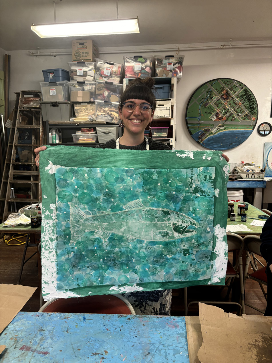 An artist holding up a finished fish print in the BCAC studio