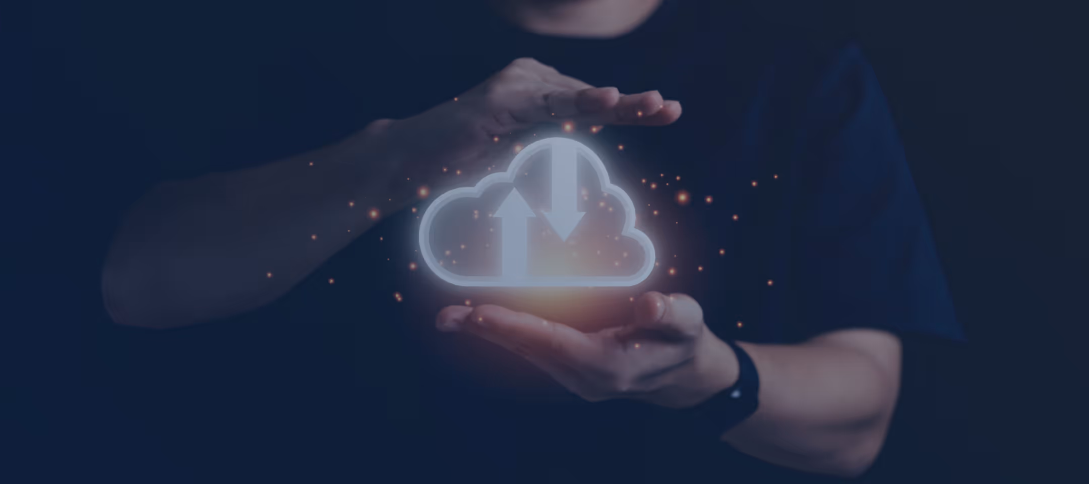 Hands framing a glowing cloud icon with upload and download arrows and floating light particles.