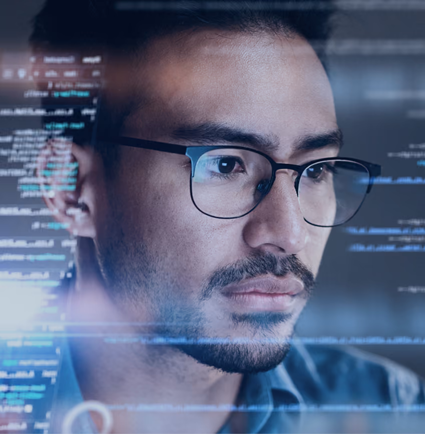 Man wearing glasses focusing on transparent screen with floating computer code and data.