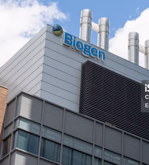 Corner of a modern Biogen building with metal vents and chimneys under a cloudy sky.