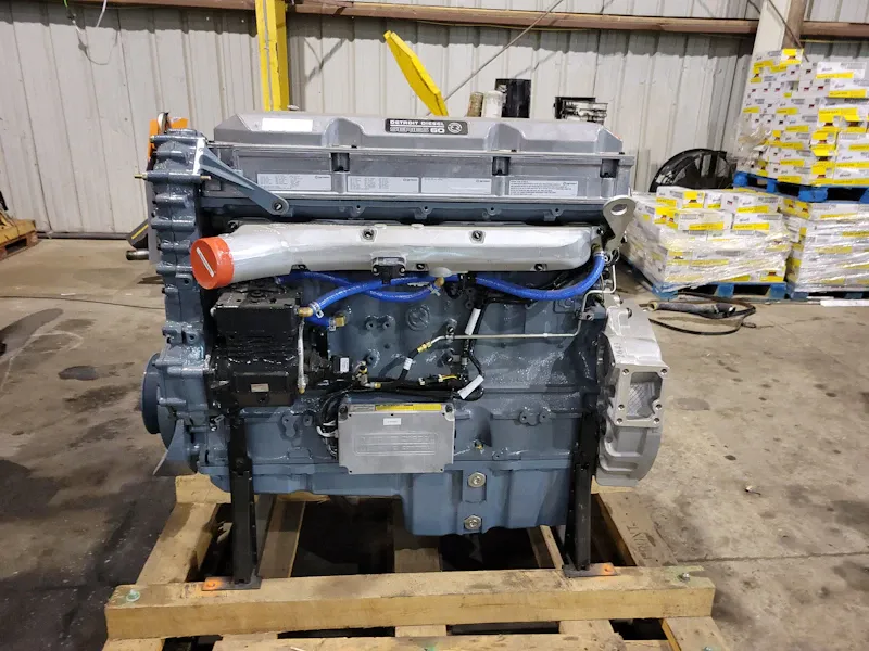 Engine rebuild featuring a Detroit Diesel Series 60 heavy-duty truck engine fully assembled on a wooden shipping stand.