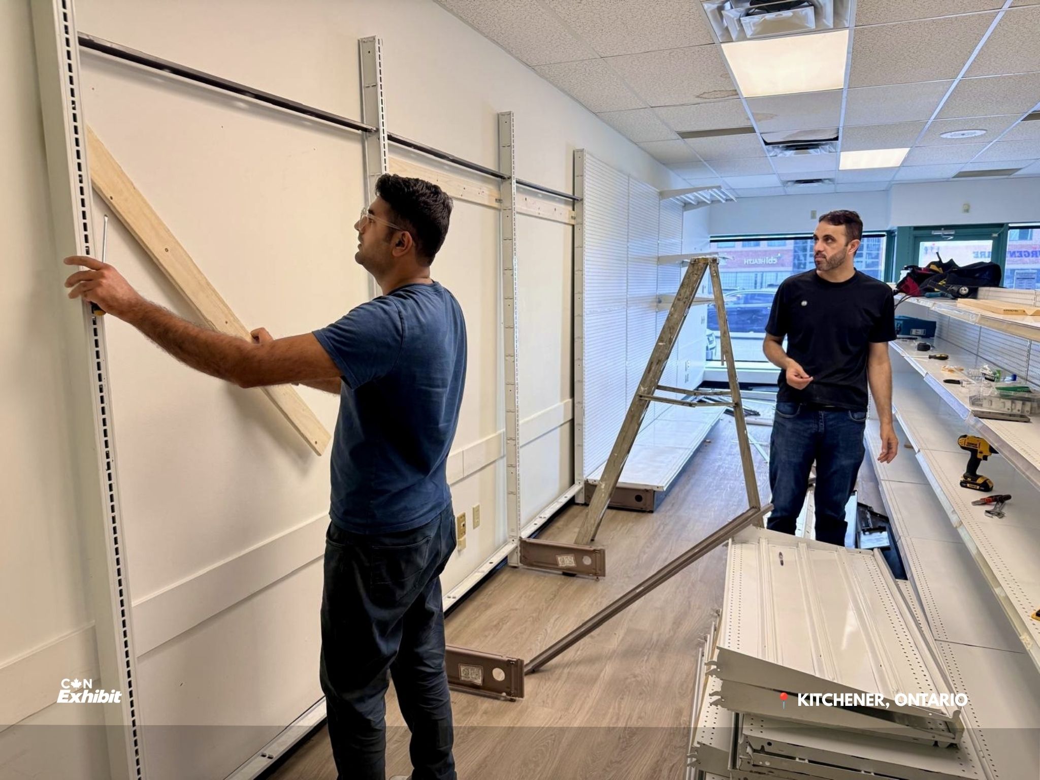 Crew installing upright supports for wall shelving in Kitchener