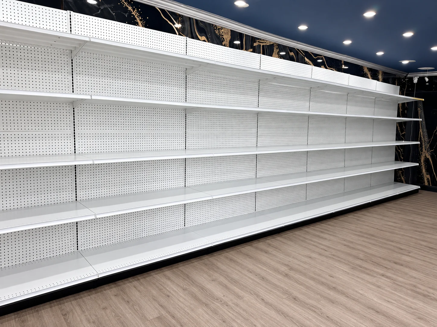 White steel wall shelving with perforated back panels and adjustable shelves