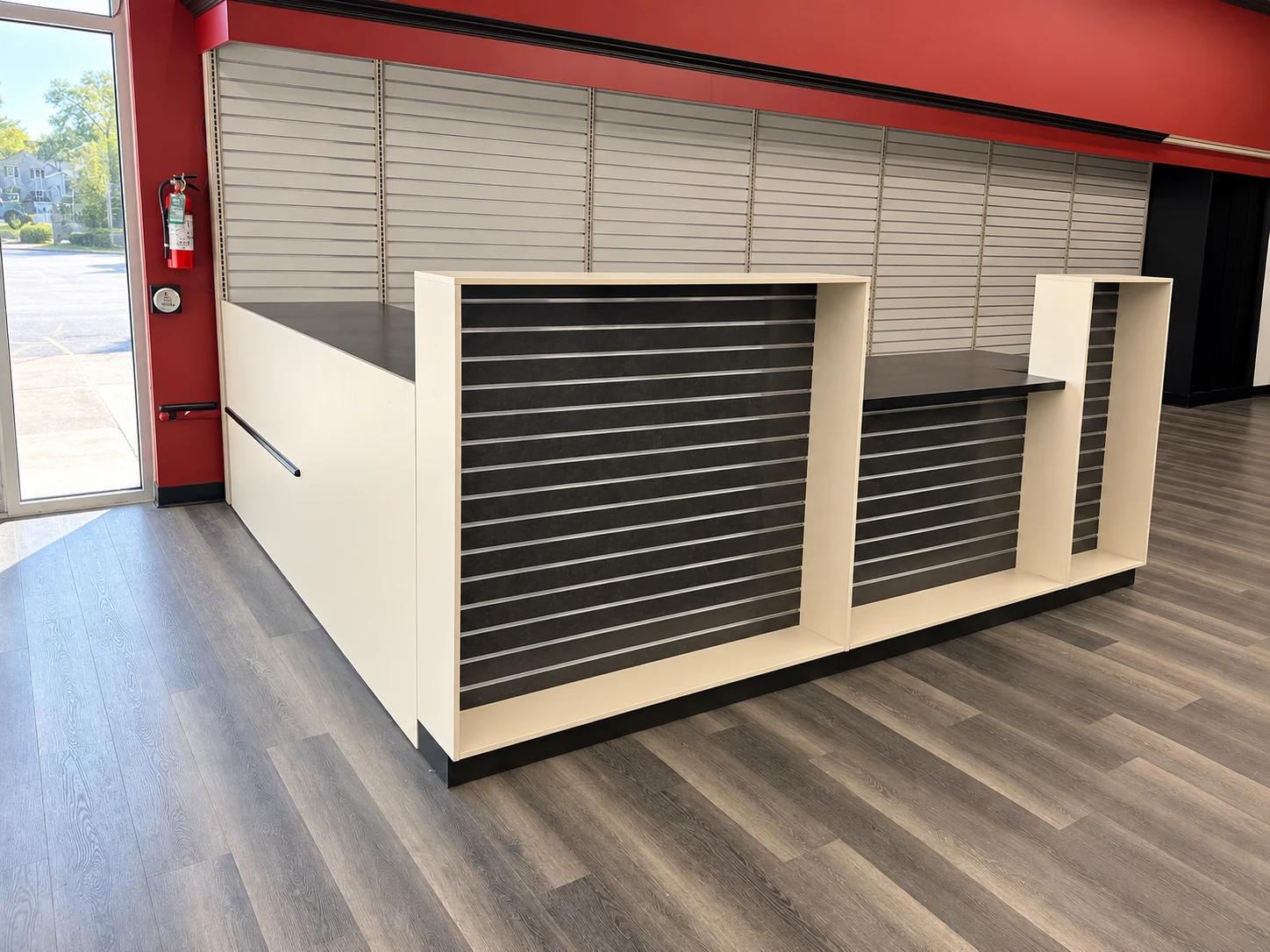 Retail checkout counter with a dark worktop and slatwall front