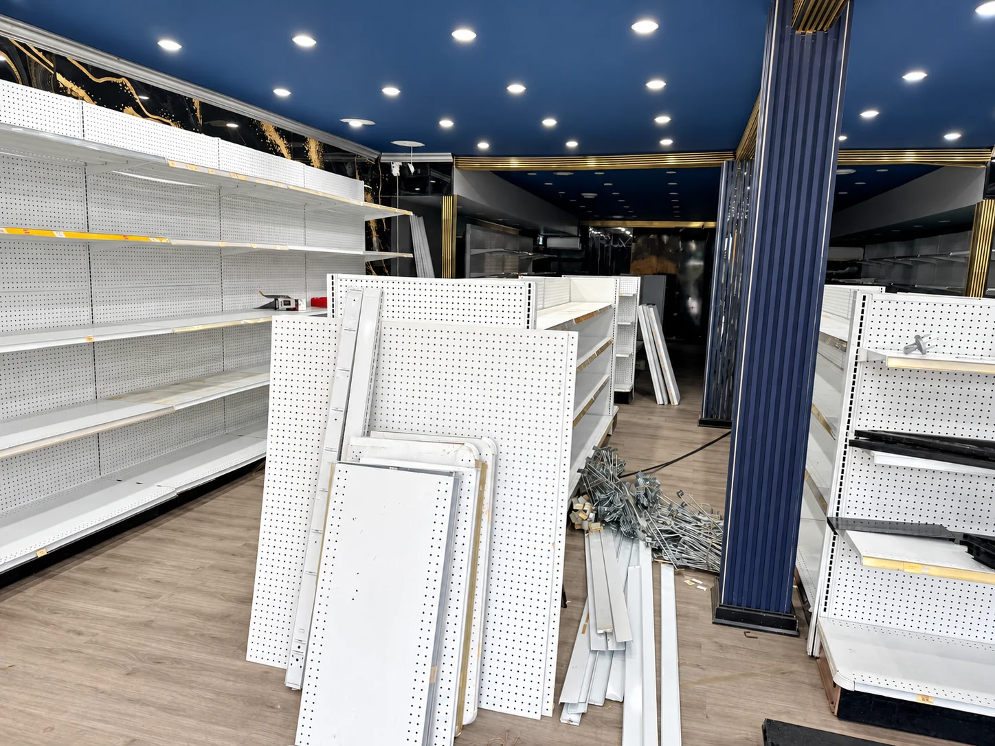 Fixture panels and components staged between the shelving runs.