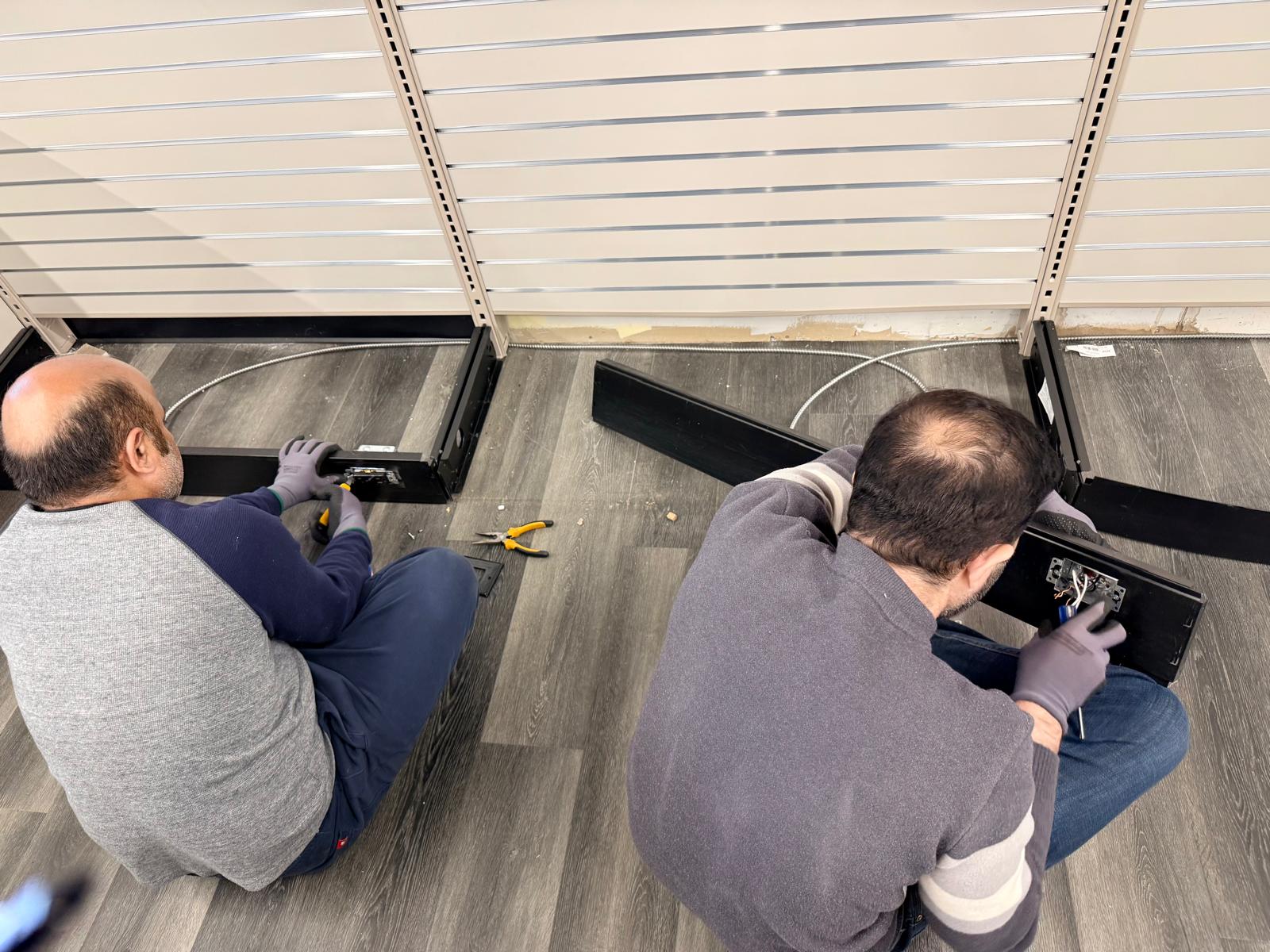 The team dismantling the lower section of a display fixture.