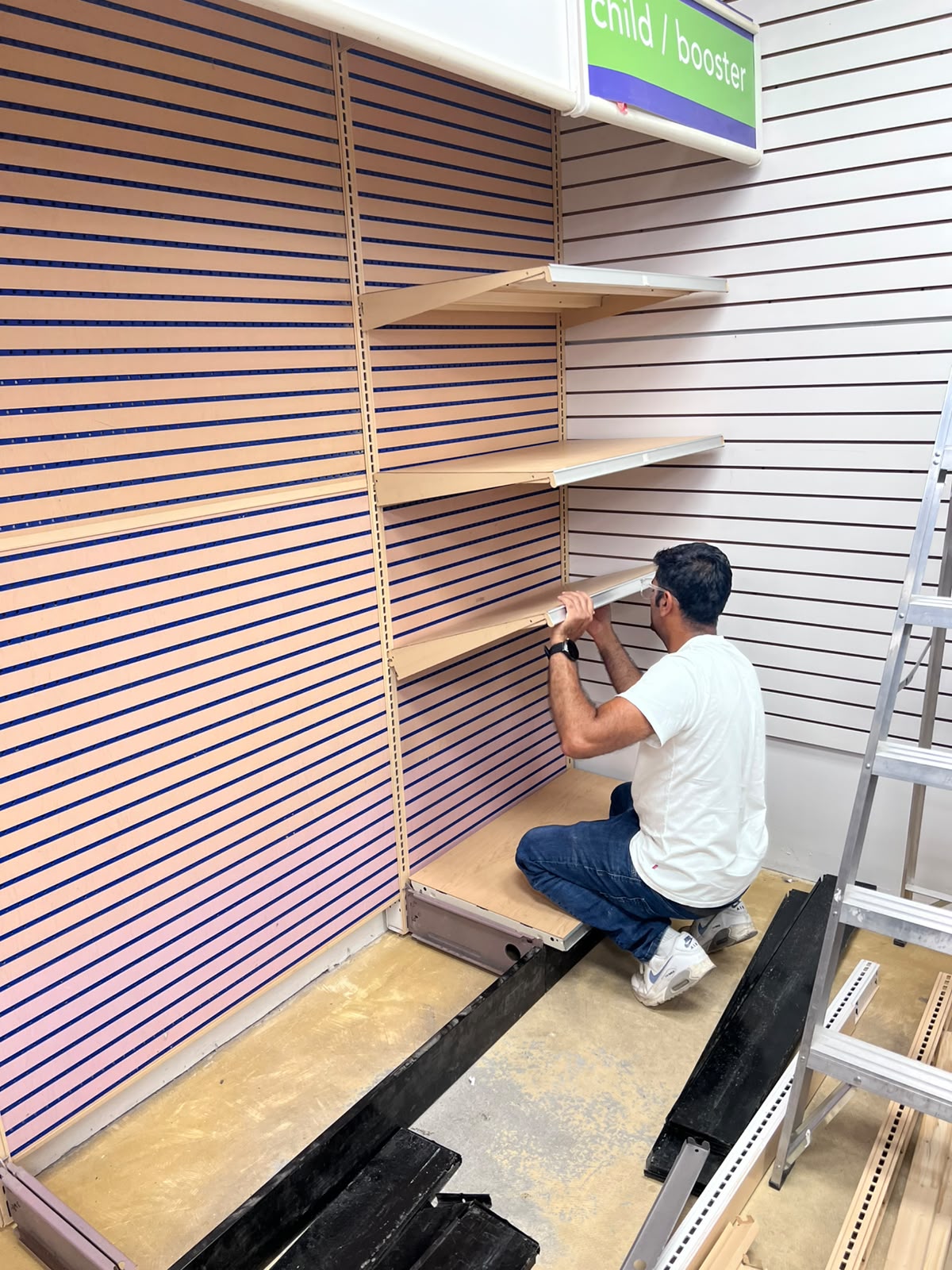 An installer fitting shelving during the Step Up Fashion setup