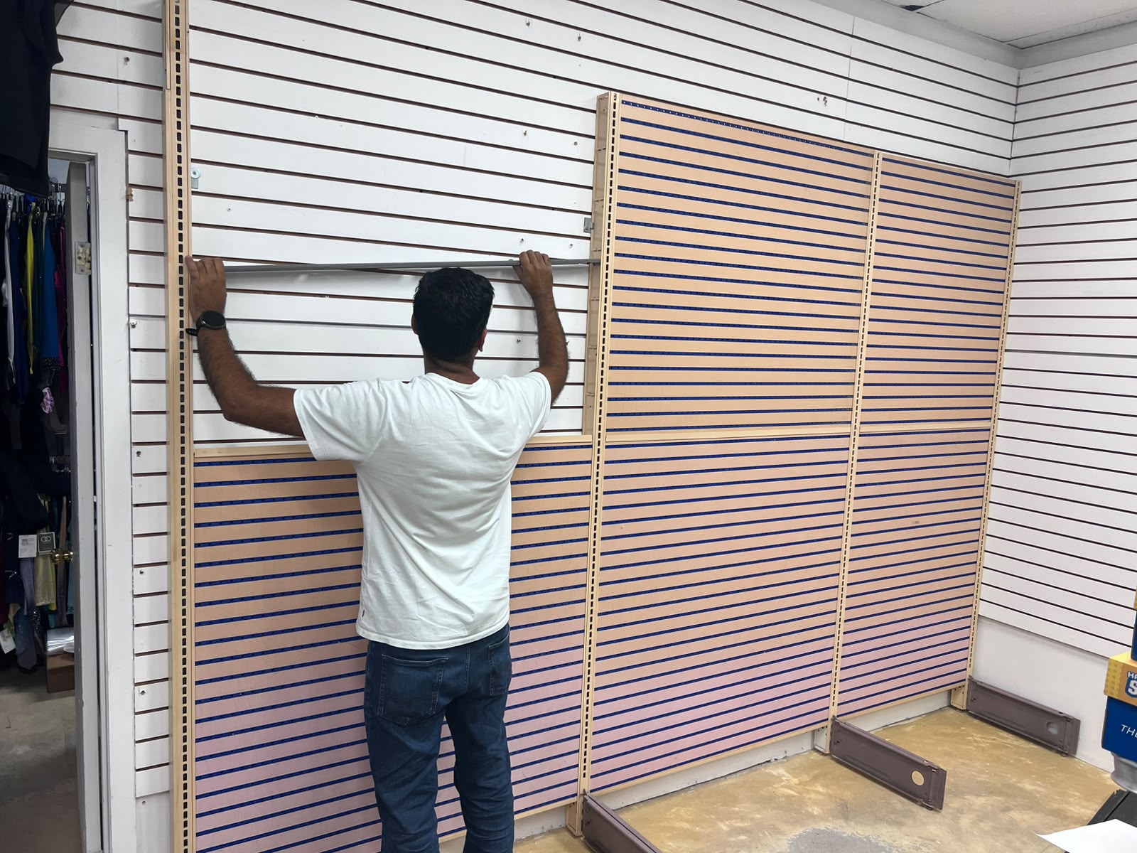 Positioning a slatwall panel as the wall display takes shape.