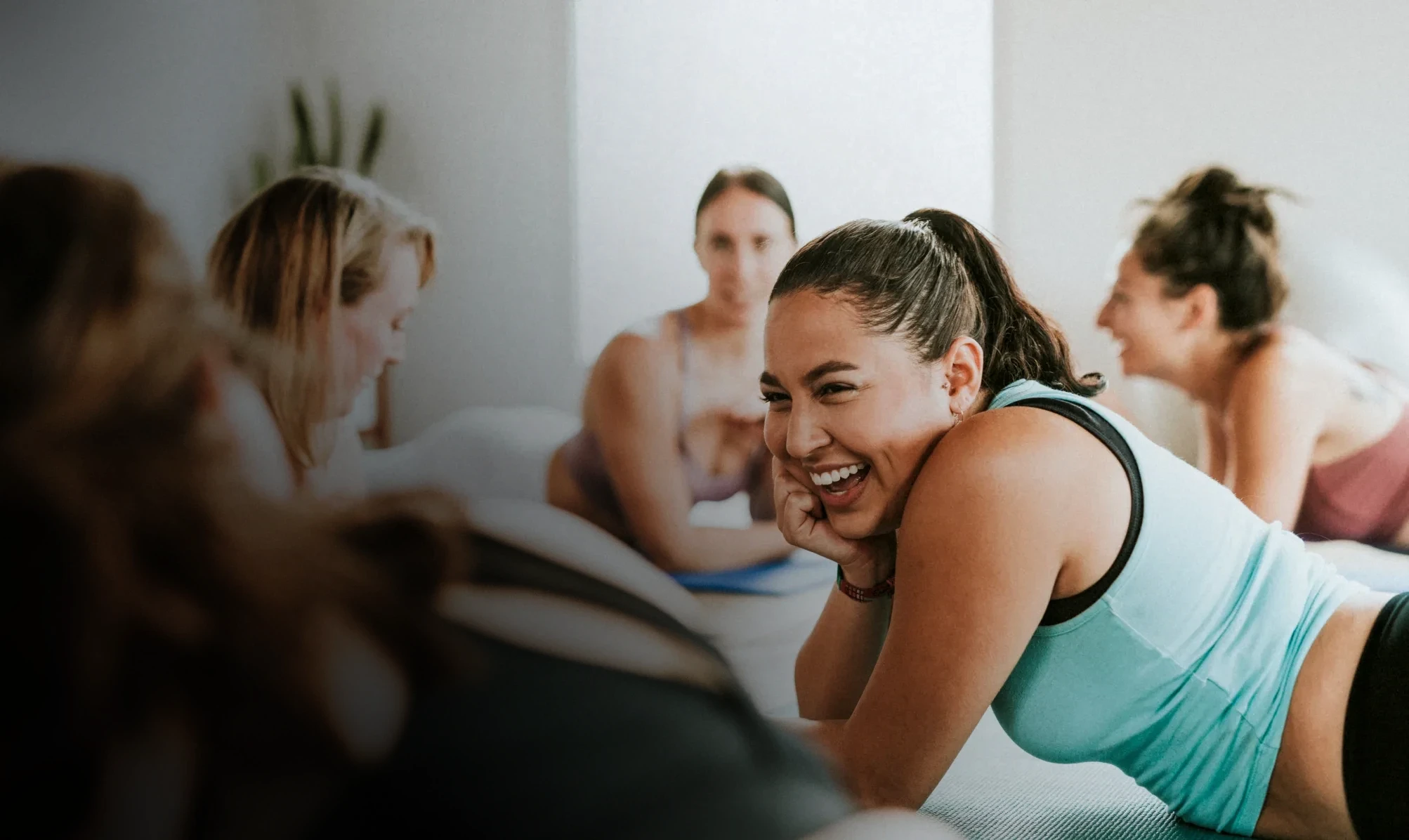 A woman in a green top smiling in her workout class. 