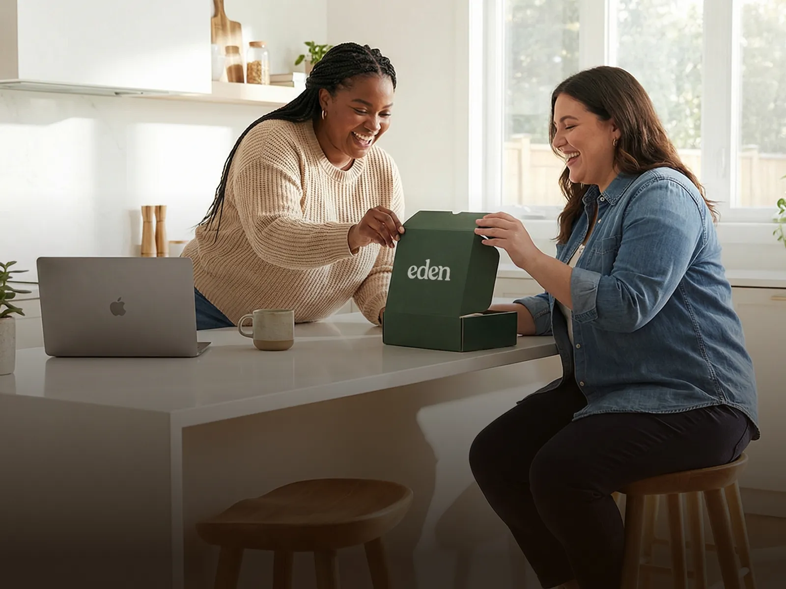 Two women in a kitchen happily talking over an Eden box