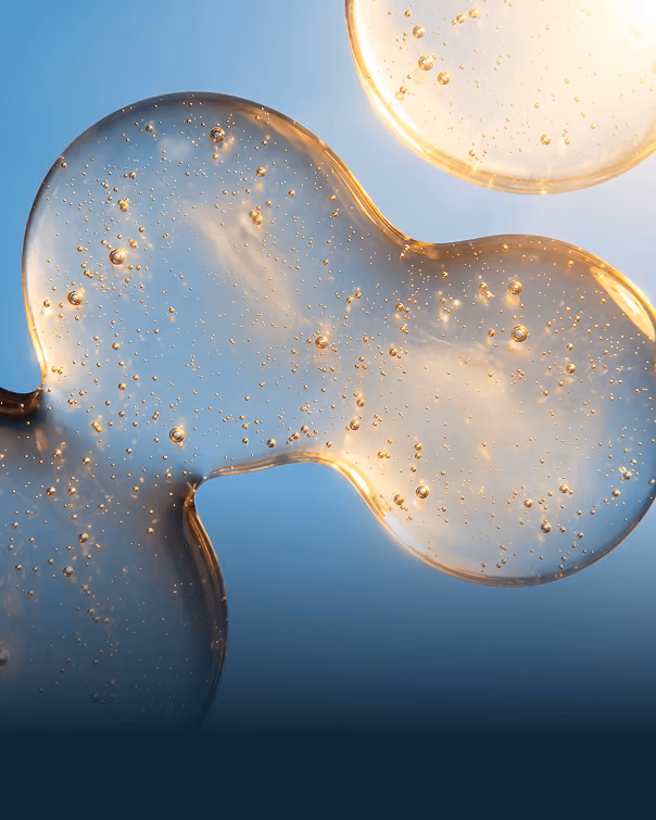 Two translucent gel blobs with bubbles inside against a blue background.