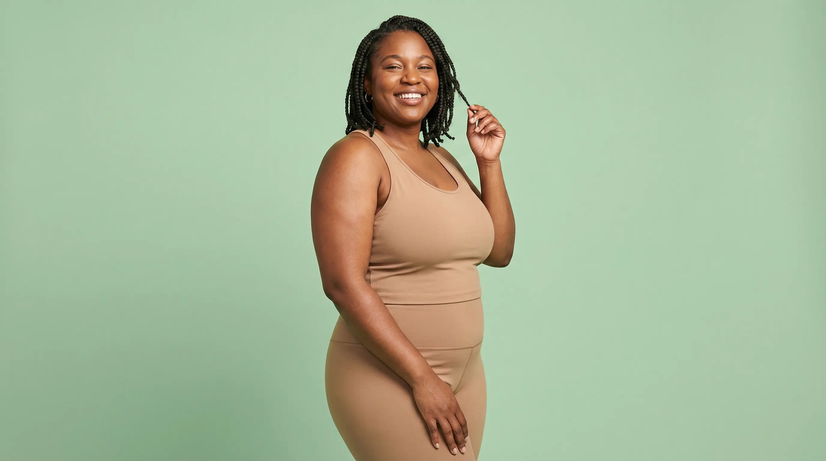 Smiling woman in neutral activewear for an article about Foundayo and oral GLP-1 weight loss options.