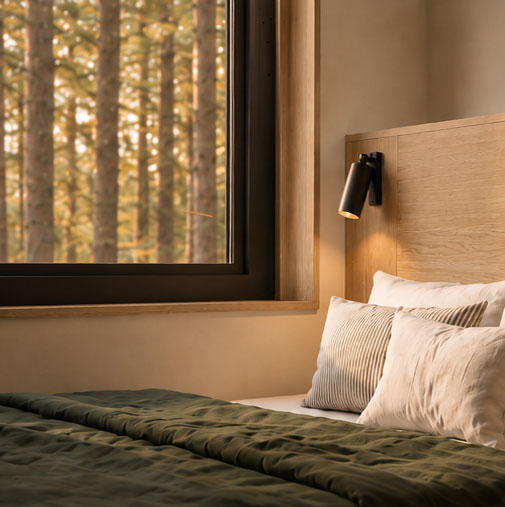 Dormitorio del Open Studio con ventana al bosque. "Habitar Distinto"