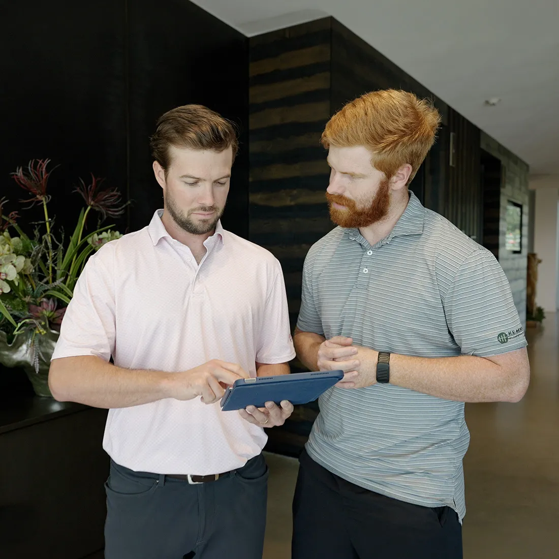 Two professionals reviewing information on a tablet