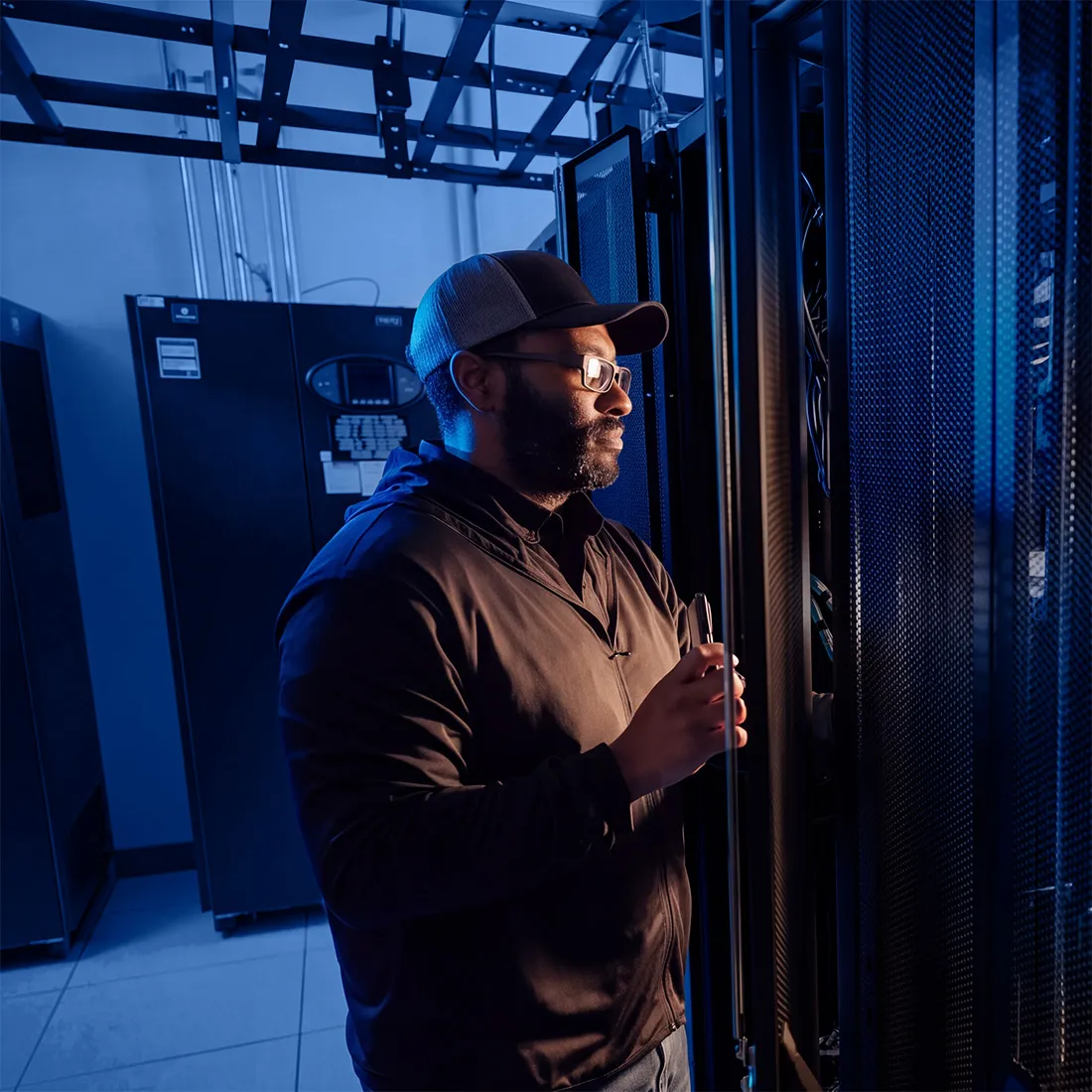 Technician inspecting server racks in a data center