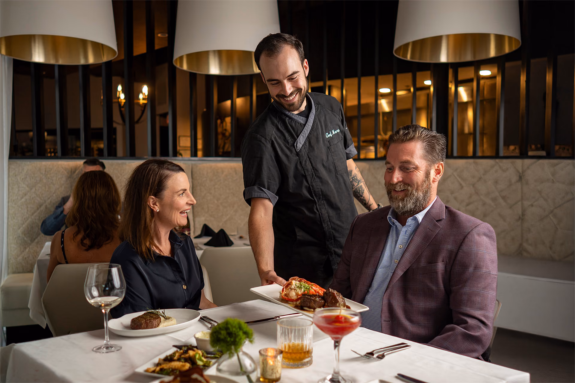 Chef serving dinner to guests at an upscale Rockwall restaurant