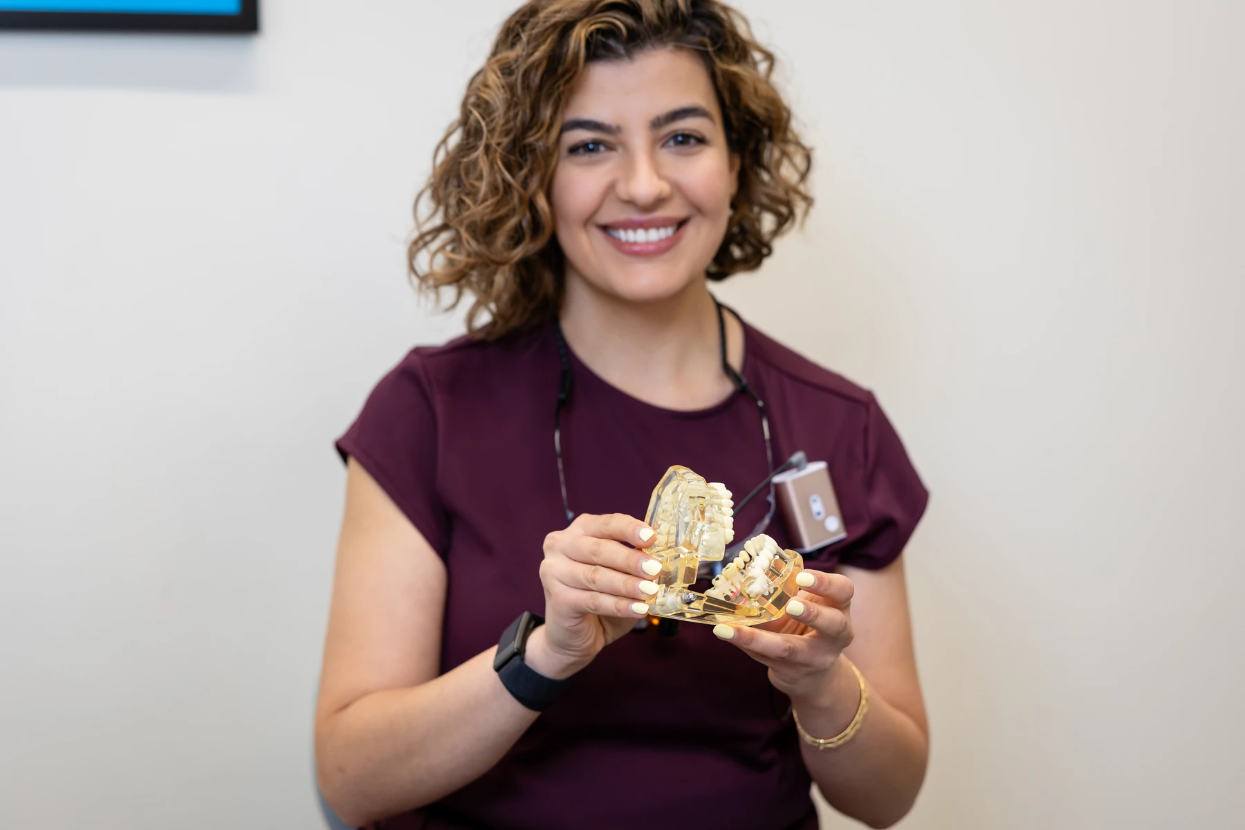 Dentist holding a model showing implant-supported restorations